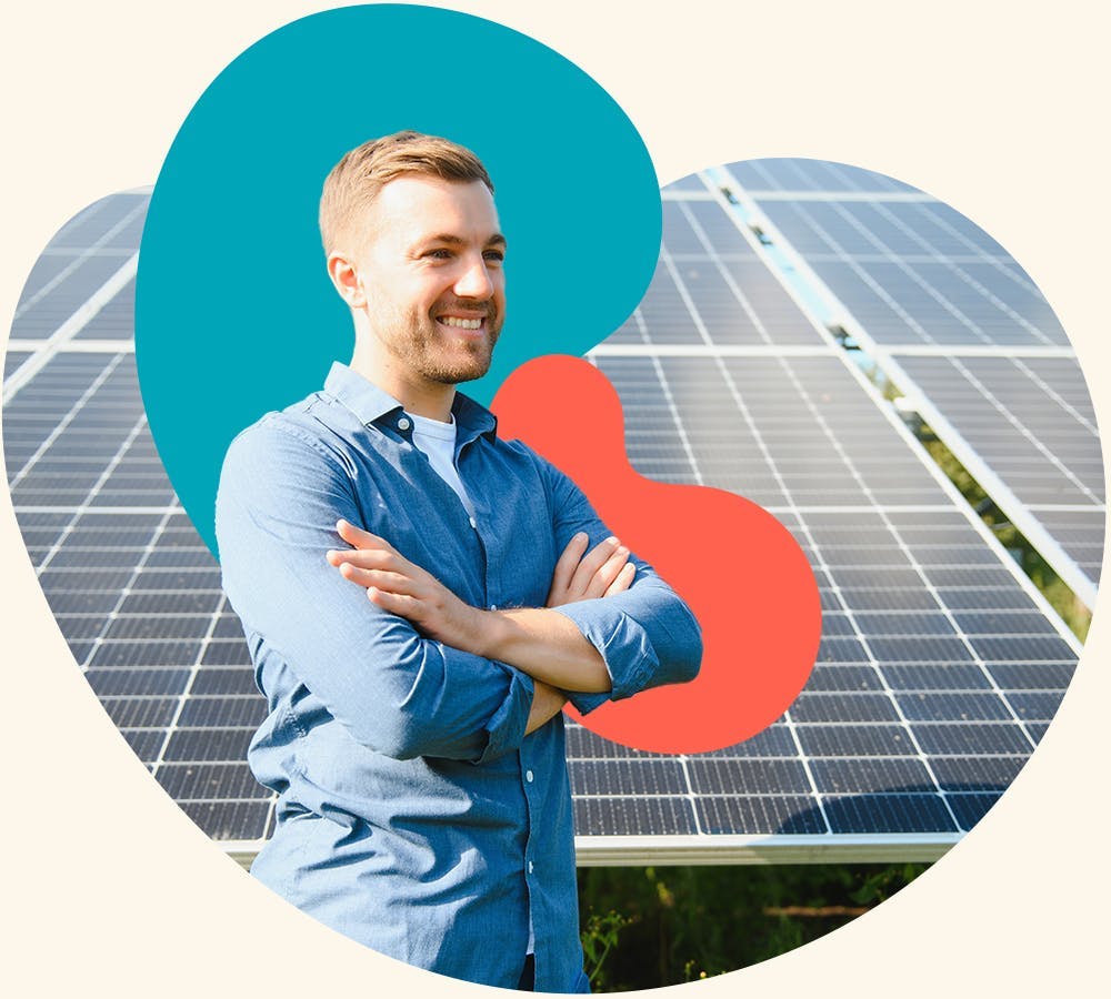 A man standing in front of sun solar panels cross armed looking happy and successful