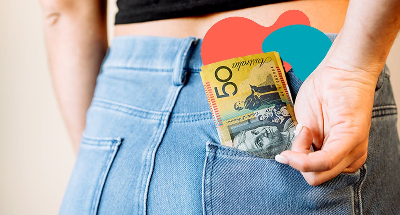 a woman is putting a $50 note in her back pocket