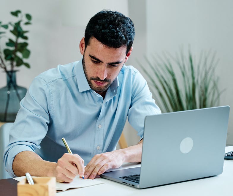 Man at desk with a laptop working as a contractor from home